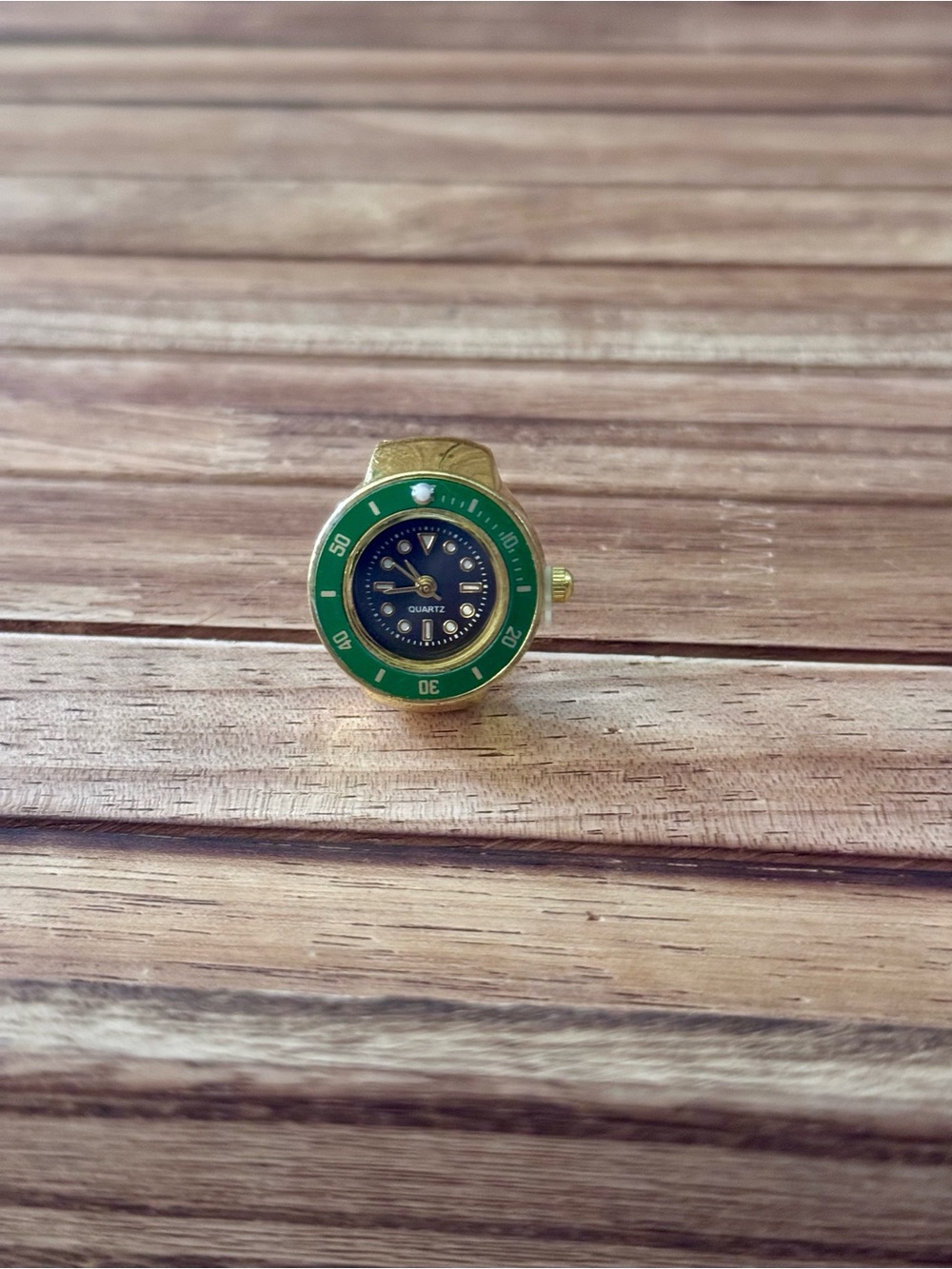 Gold Tone Ring Watch with Green Bezel and Navy Dial